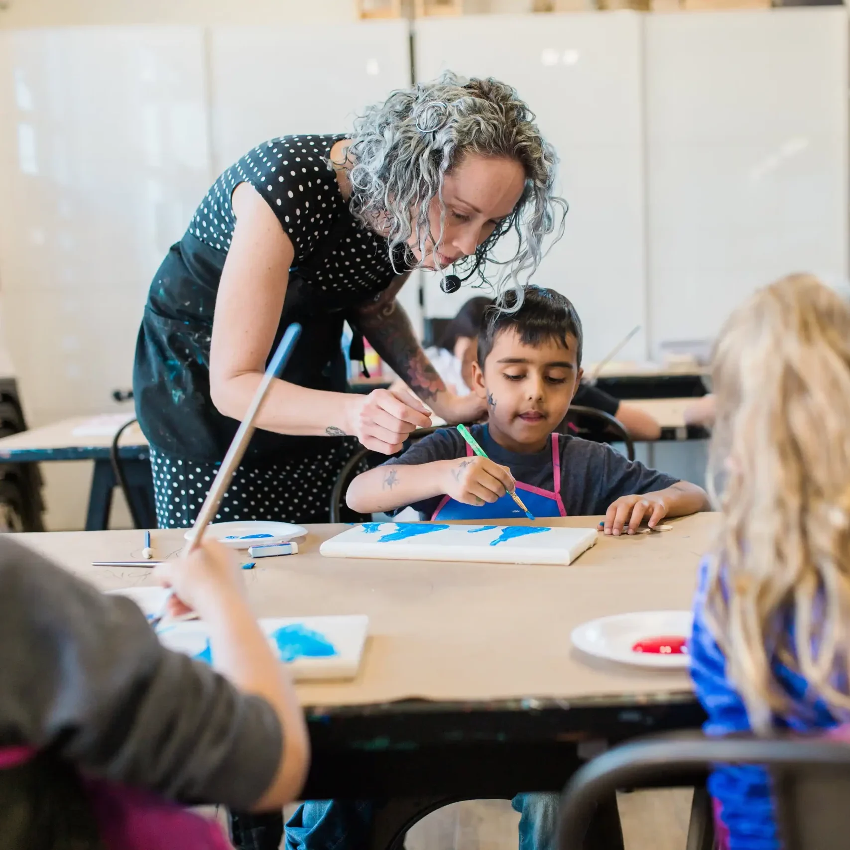 A young person taking part in an arts activity with an instructor